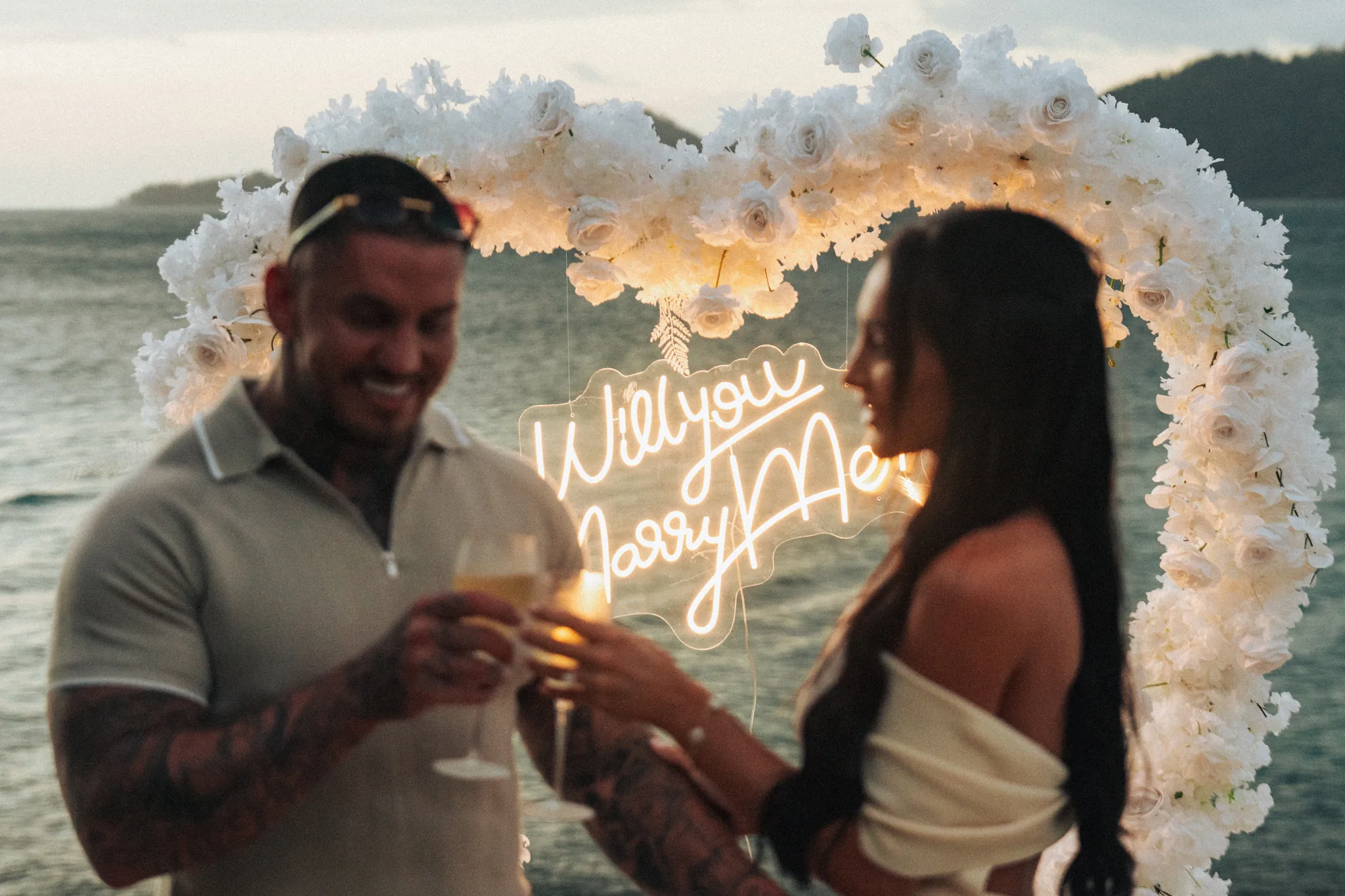 The couple holds sparklers shaped into a glowing heart at night